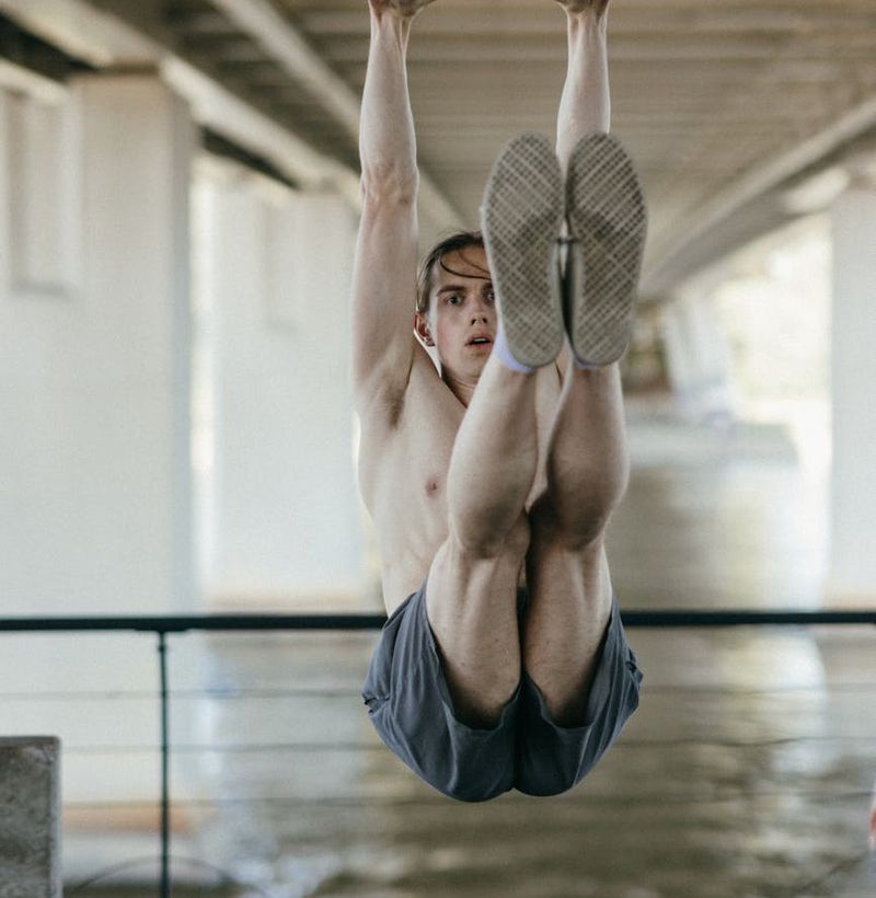 Man performing a controlled bodyweight exercise in a spacious room.